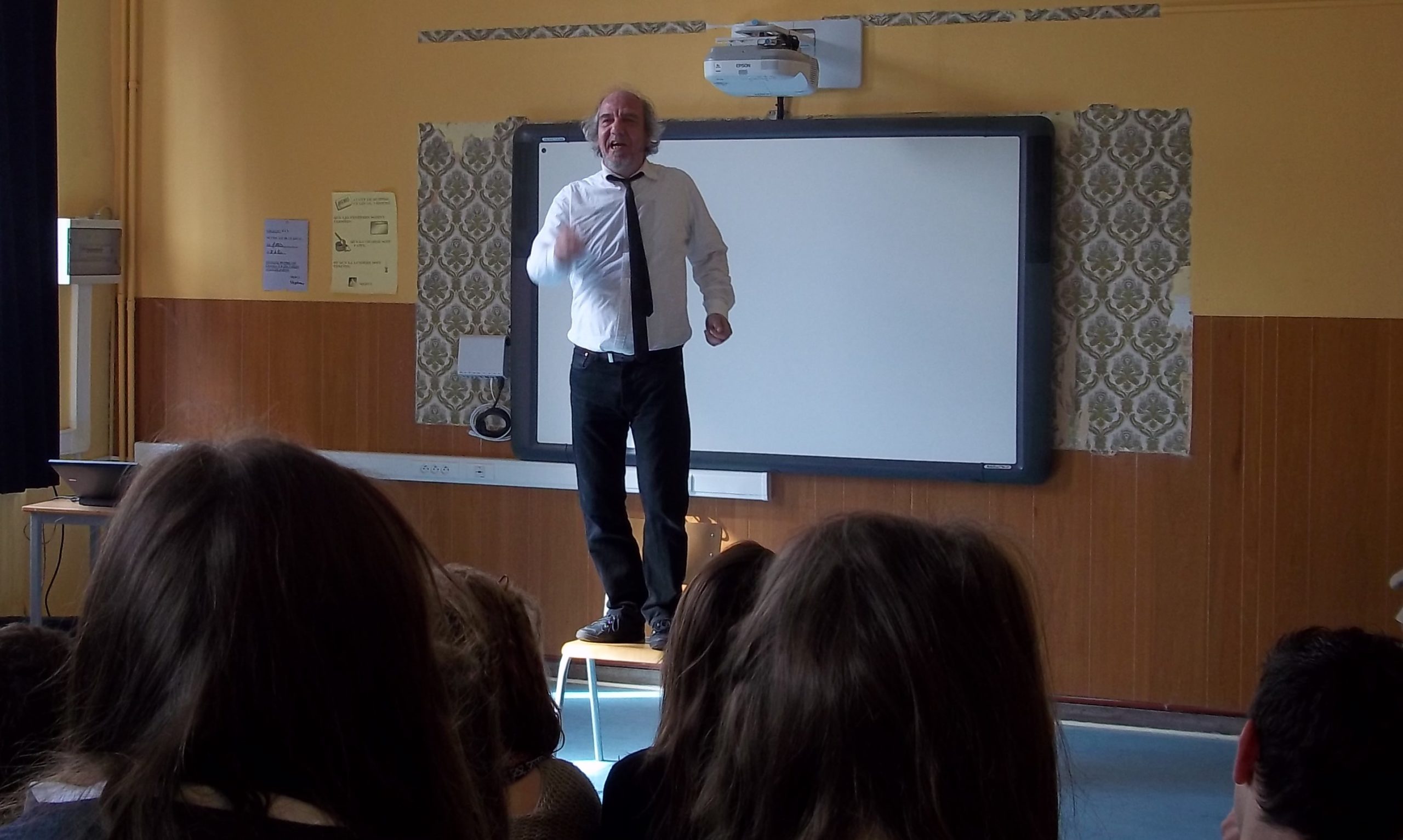 Comédien sur une estrade devant une classe